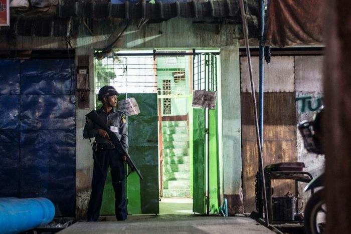 A policeman secures the entrance to the immigration office in South Dagon, a suburb of Yangon, following multiple explosions on November 24, 2016