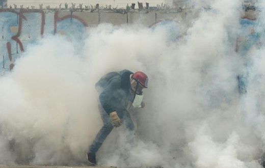 Riot police and pro-government vigilantes fought running battles in Caracas with protesters demanding the ouster of President Nicolas Maduro