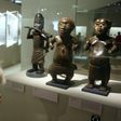 A visitor looks at a statue in brass representing a horn player (L, Benin, South of Nigeria, XVIth and XVIIth Century) during an exhibition focused on refined Art in Benin in 2007 at the Quai Branly museum in Paris