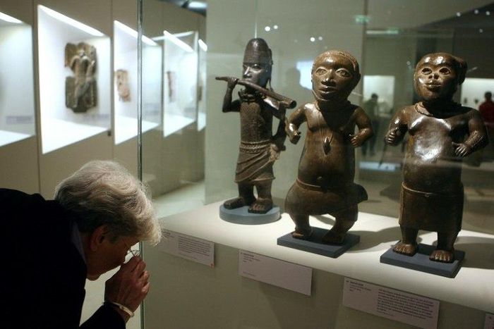 A visitor looks at a statue in brass representing a horn player (L, Benin, South of Nigeria, XVIth and XVIIth Century) during an exhibition focused on refined Art in Benin in 2007 at the Quai Branly museum in Paris
