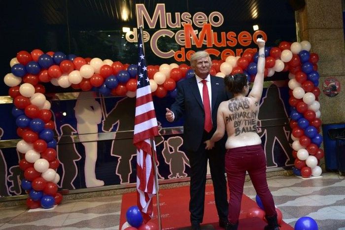 A topless Femen activist protests in front of the wax statue of US President-elect Donald Trump at the Wax Museum of Madrid on January 17, 2017