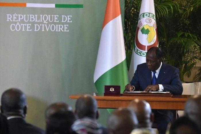 Ivory Coast's president Alassane Ouattara signs the country's revisited constitution on November 8, 2016 at the presidential palace in Abidjan