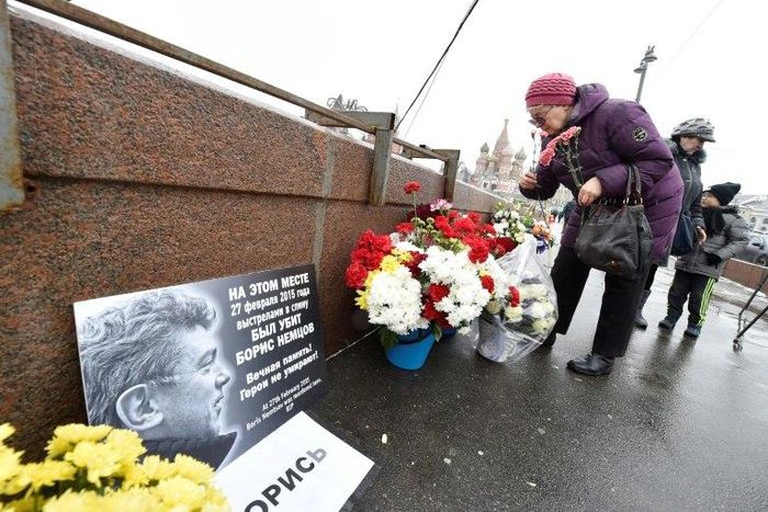 A woman lays flowers in Moscow at the site where Russian opposition leader Boris Nemtsov was shot dead to mark the second anniversary of his assassination in February 2017