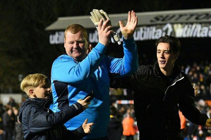 Sutton United's reserve goalkeeper Wayne Shaw (C) applauds supporters after the club's FA Cup fifth round defeat to Arsenal at the Borough Sports Ground, Gander Green Lane in south London on February 20, 2017