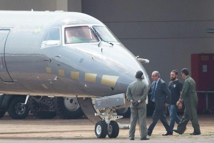 Eduardo Cunha was photographed being led to an airplane in the capital Brasilia under the eye of several guards, including a so-called 'hipster cop' which has caught the attention of Brazilian media