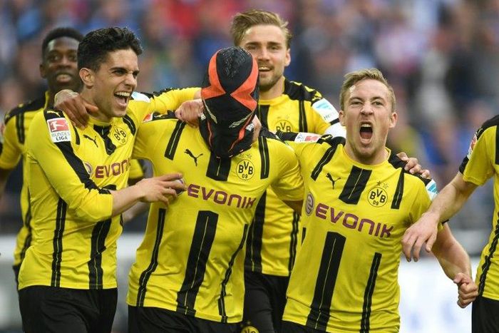 Dortmund's Pierre-Emerick Aubameyang (C) wears a mask as he celebrates with teammates after scoring against Schalke in Gelsenkirchen, western Germany, on April 1, 2017