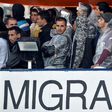 Migrants and refugees look on as they are on board of the Topaz Responder, a rescue ship run by Maltese NGO MOAS during its arrival at the Brindisi's harbour on October 27, 2016