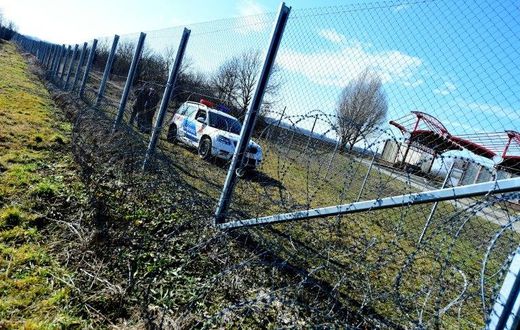 Local police officials patrol in front of a part of the border fence of the Hungarian-Croatian border at the Beremend border crossing point on February 23, 2017