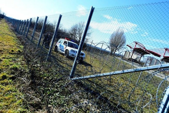 Local police officials patrol in front of a part of the border fence of the Hungarian-Croatian border at the Beremend border crossing point on February 23, 2017
