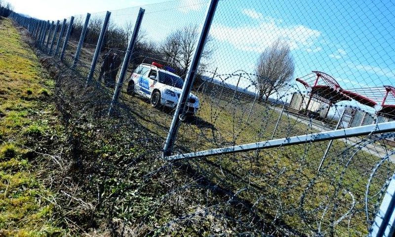 Local police officials patrol in front of a part of the border fence of the Hungarian-Croatian border at the Beremend border crossing point on February 23, 2017