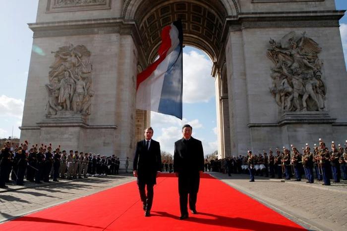 French President Emmanuel Macron, left, and Chinese President Xi Jinping laid a wreath before the eternal flame at the Arc de Triomphe in Paris on Monday