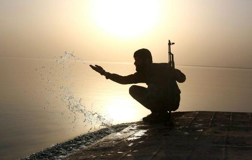 A member of the US-backed Syrian Democratic Forces splashes water at Lake Assad on April 29, 2017