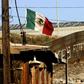 A Mexican flag flies next to the wall which separates Mexico from the United States in Tijuana