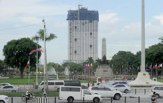 The 49-storey Torre de Manila high-rise condominium looms in the background from the Jose Rizal tomb and monument at Luneta Park in Manila