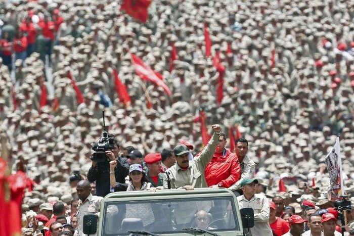 Venezuelan President Nicolas Maduro (C) saluting next to his wife Cilia Flores as they arrive for the celebrations for the seventh anniversary of the Bolivarian Militia in Caracas on April 17, 2017
