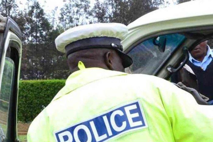 A traffic police officer inspects a matatu