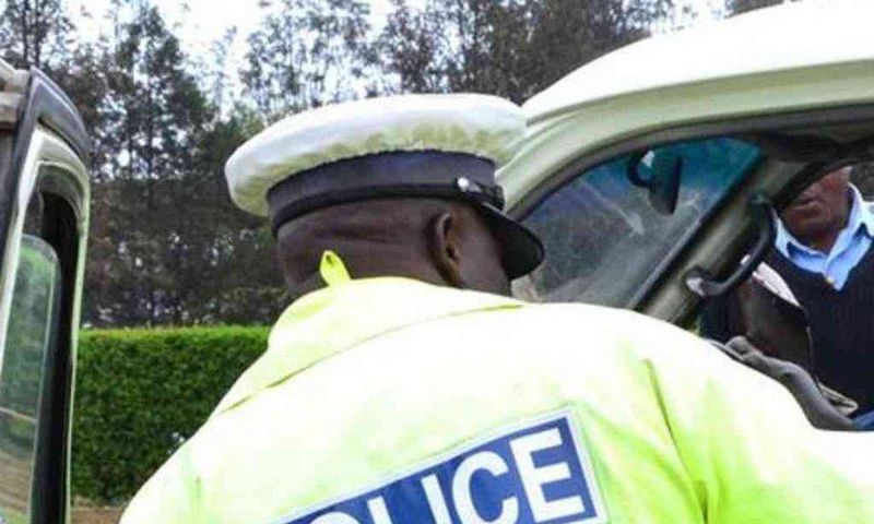 A traffic police officer inspects a matatu