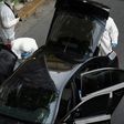 Forensic experts of the police search for evidence in and around the car of Greek former prime minister Lucas Papademos in Athens on May 25, 2017