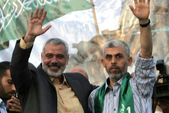 Freed Palestinian prisoner Yahya Sinwar (R), a founder of Hamas' military wing, and then Hamas leader Ismail Haniya wave as supporters celebrate the release of prisoners in Khan Yunis, southern Gaza Strip on October 21, 2011