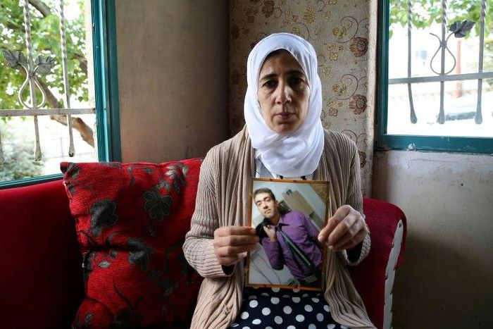 Manal al-Saayed, the mother of Israeli citizen Hisham al-Sayed, holds a picture of her son who is believed to have been held by Hamas since April 2015