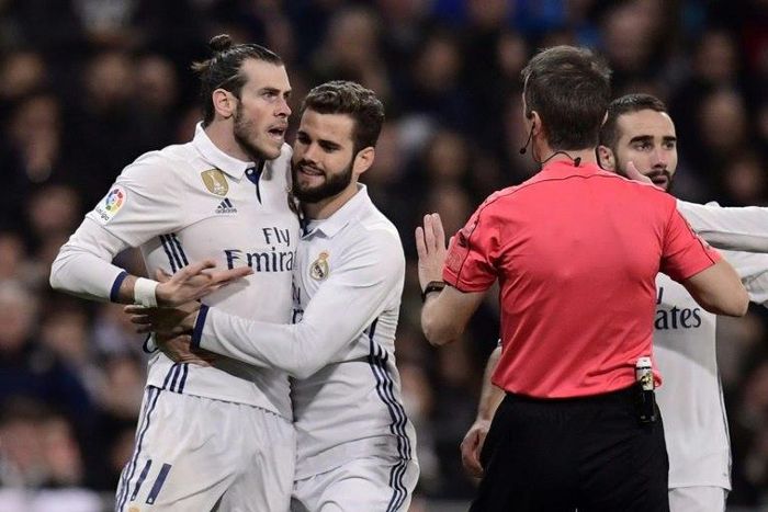 Real Madrid's Welsh forward Gareth Bale (L) argues with the referee as teammates try to stop him during their match against D Las Palmas at the Santiago Bernabeu stadium in Madrid on March 1, 2017