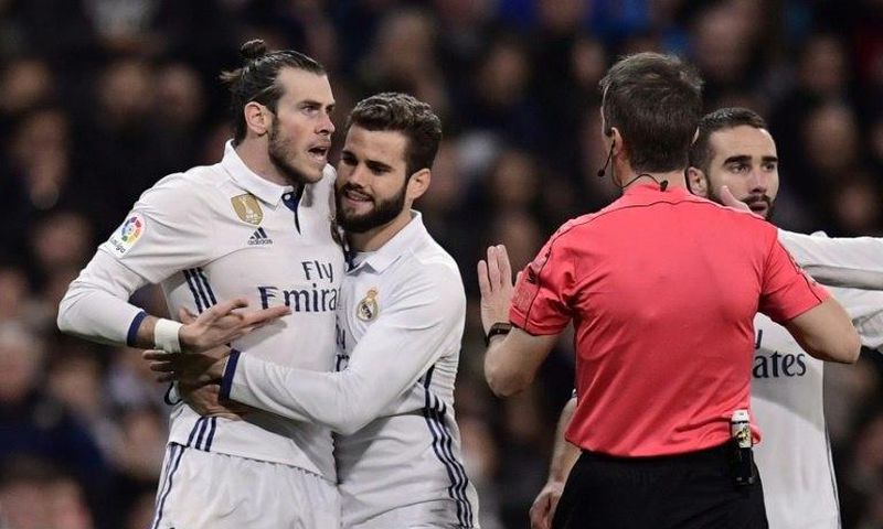 Real Madrid's Welsh forward Gareth Bale (L) argues with the referee as teammates try to stop him during their match against D Las Palmas at the Santiago Bernabeu stadium in Madrid on March 1, 2017