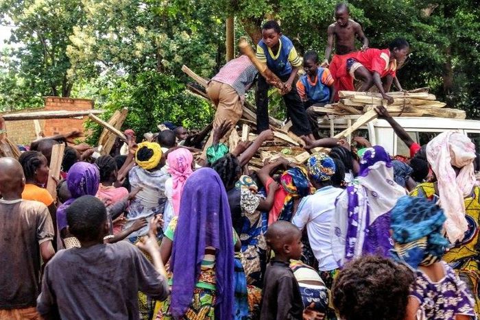 Central African internal-displaced people gather around a truck where volunteers distribute fire wood in Bangassou. At least 108 people were slaughtered and 76 injured during an attack by several hundred fighters on the town on May 13