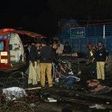 Pakistani policemen and volunteers move the bodies of victims at the site of a bomb explosion in Lahore on February 13, 2017