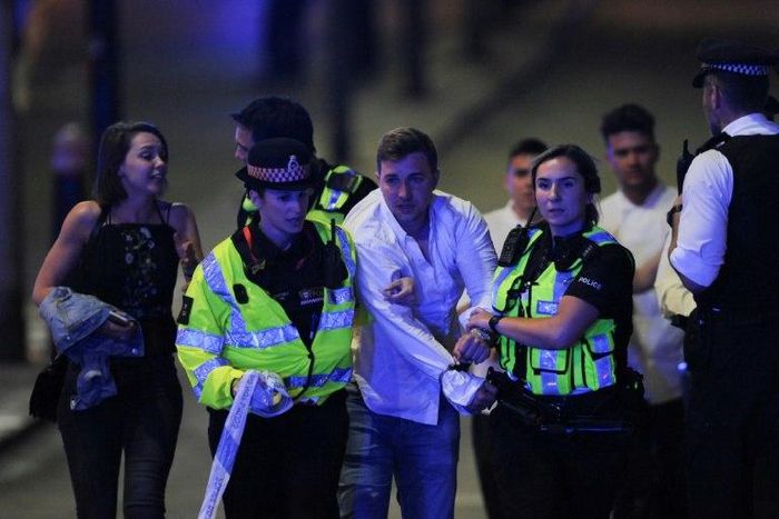 Police help people clear the scene after a terror attack on London Bridge on June 3, 2017