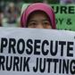 An Indonesian migrant worker holds up a placard during a vigil for slain colleagues Seneng Mujiasih and Sumarti Ningsih in Hong Kong