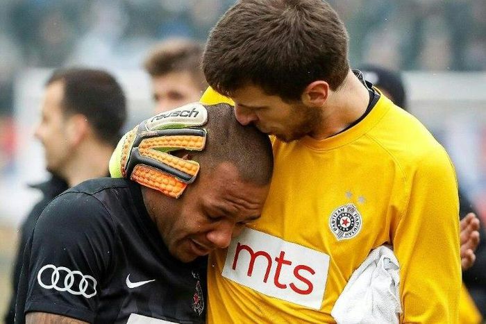 Partizan Belgrade's goalkeeper Filip Kljajic (right) hugs Everton Luiz as he leaves the field in tears on February 19, 2017
