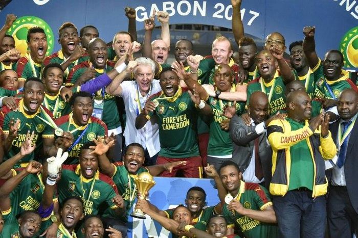Cameroon team players and coach Hugo Broos (C) celebrate with the winner's trophy after beating Egypt 2-1 to win the 2017 Africa Cup of Nations final football match on February 5, 2017
