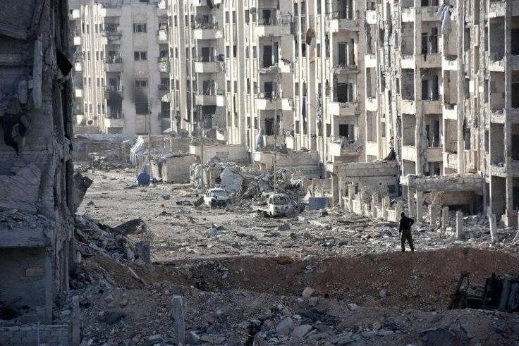 A person stands amid heavily damaged buildings in Aleppo's 1070 district on November 8, 2016, after troops seized it from rebel fighters