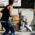 Palestinian protesters use slingshots to hurl stones towards Israeli security forces during clashes in the West Bank town of Bethlehem on April 21, 2017, in solidarity with the hunger striking prisoners
