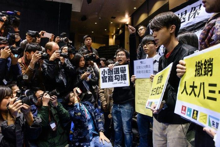 Pro-democracy protesters (R) shout slogans against former Hong Kong chief secretary and leadership hopeful Carrie Lam (not seen) before the start of a press conference by Lam in Hong Kong on February 27, 2017
