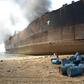 A Pakistani man looks at the wreckage of a burning ship a day after a gas cylinder explosion at the Gadani shipbreaking yard