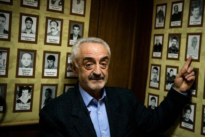 Marinko Djuric points at a photograph of his missing father who was among seven members of his family who disappeared in northwestern Kosovo during the conflict in the 1990s