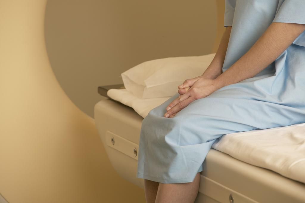 Female patient sitting nervously on scanner bed