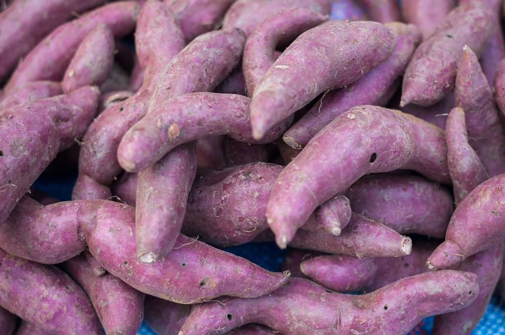 Close-up Sweet Potato purple peel yam raw many in market background