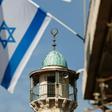 An Israeli flag is pictured in front of the minaret of a mosque in the Arab quarter of Jerusalem's Old City on November 14, 2016 Israeli Prime Minister Benjamin Netanyahu said he backed a bill limiting the volume of calls to prayer from mosques, a prop...