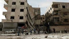 People inspect a hospital, damaged following an air strike a rebel-controlled town in the eastern Ghouta region on the outskirts of the capital Damascus on May 1, 2017