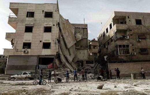 People inspect a hospital, damaged following an air strike a rebel-controlled town in the eastern Ghouta region on the outskirts of the capital Damascus on May 1, 2017