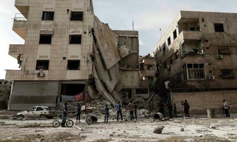 People inspect a hospital, damaged following an air strike a rebel-controlled town in the eastern Ghouta region on the outskirts of the capital Damascus on May 1, 2017