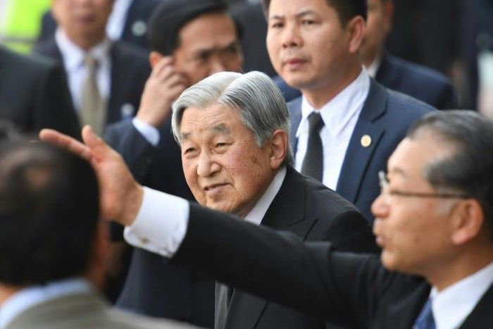Japan's Emperor Akihito (C) flanked by security men arrives at Phu Bai airport in Vietnam's central city of Hue as they prepare to depart for Thailand, ending their six-day long royal visit in the communist country on March 5, 2017