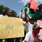 Demonstrators from the Indigenous People of Biafra (IPOB) group wave flags and hold a sign reading "Freedom for Biafra" during a protest in Abidjan on September 23, 2016 calling for the release of pro-Biafra leader Nnamdi Kanu