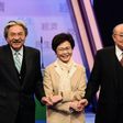 Hong Kong's three leadership candidates (L-R) John Tsang, Carrie Lam and ex-judge Woo Kwok-hing join hands in a Hong Kong TV studio before facing off in their first televised debate on March 14, 2017