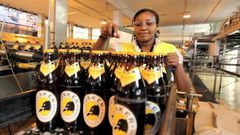 A file photo of an employee inspecting beer at an East African Breweries Ltd factory.