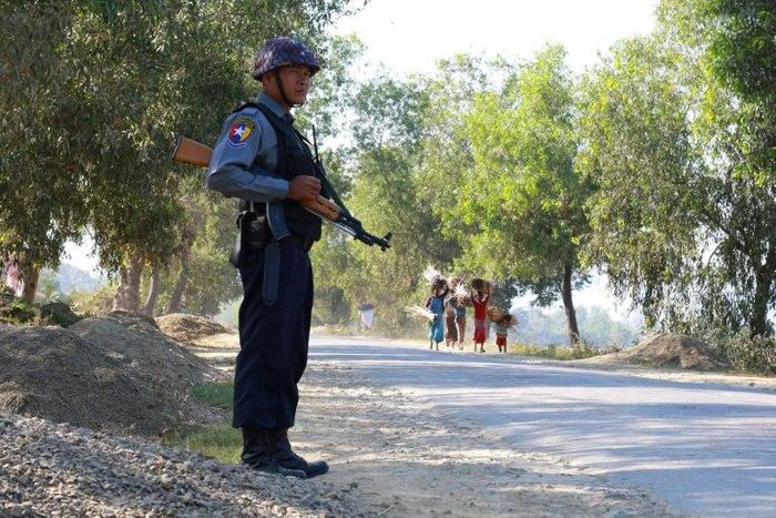 An armed Myanmar police officer is posted on the road during the arrival of the UN special rapporteur on Myanmar in Buthidaung, northern Rakhine State on January 14, 2017