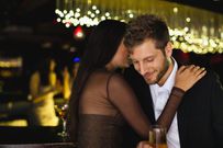 Smiling couple whispering at bar