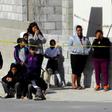 A police officer (L) and neighbors watch a house where five people were killed in Mexico's Ciudad Juarez on January 16, 2019 -- the country suffered a record 33,341 homicides in 2018